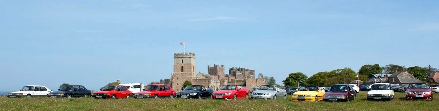 Saabs lined up with Bamburgh Castle in the background.